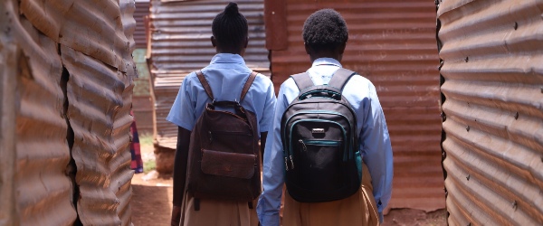 Twee meisjes met schooltas op hun rug