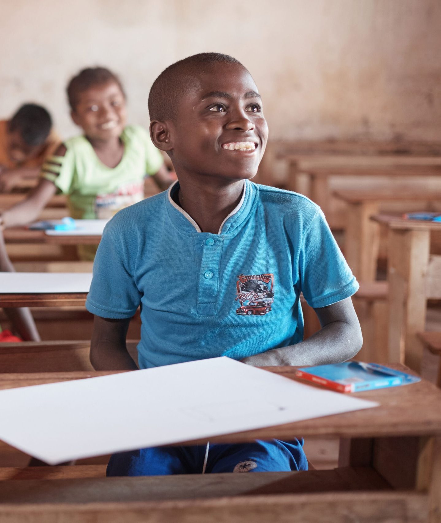 Messi en andere studenten uit Madagaskar zitten lachend in de klas